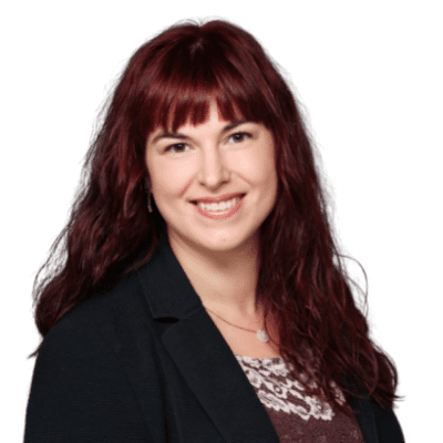 Frau mit roten Haaren lächelt freundlich.