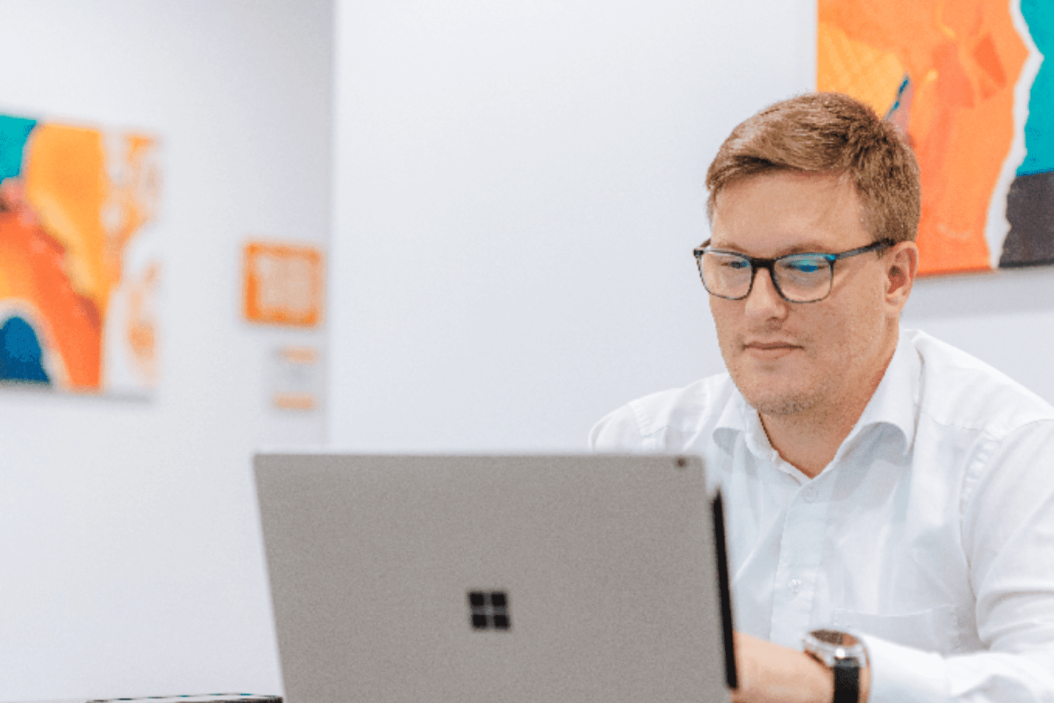 Mann arbeitet am Laptop im Büro.