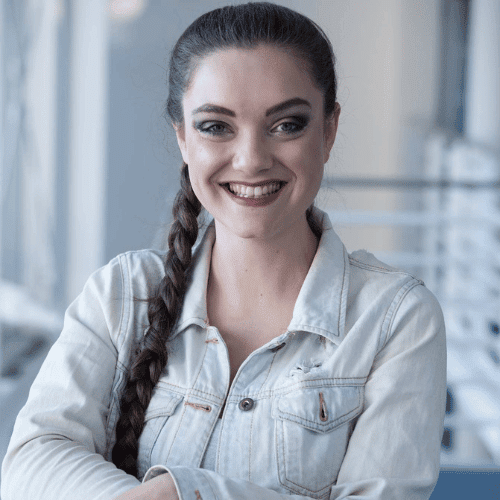 Frau mit Zopf lächelt freundlich.