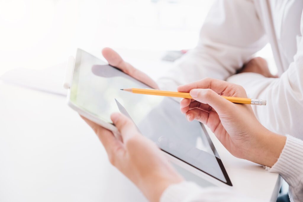 Person mit Stift und Tablet bei der Arbeit.